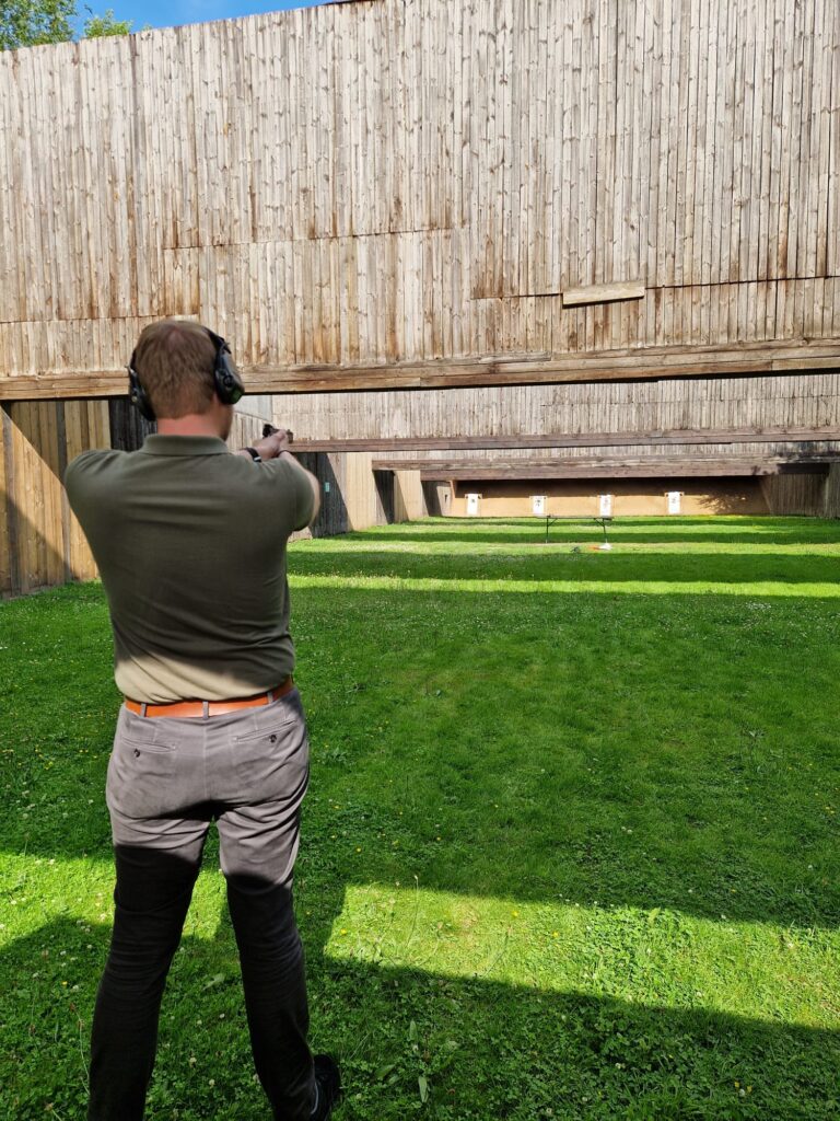 Outdoor Schießstand im Sommer. Ein Schütze versucht mit der Pistole auf 50m zu treffen.